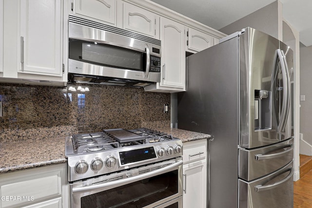 kitchen featuring white cabinetry, stone countertops, stainless steel appliances, and hardwood / wood-style floors