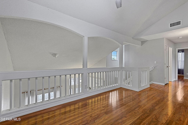 spare room with hardwood / wood-style floors, a textured ceiling, and high vaulted ceiling