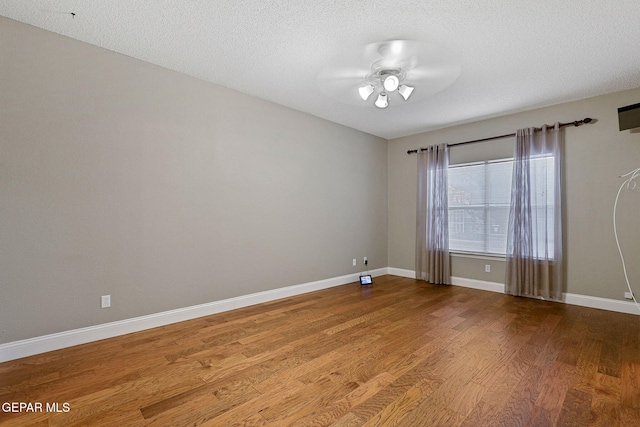 spare room with a textured ceiling, wood-type flooring, and ceiling fan