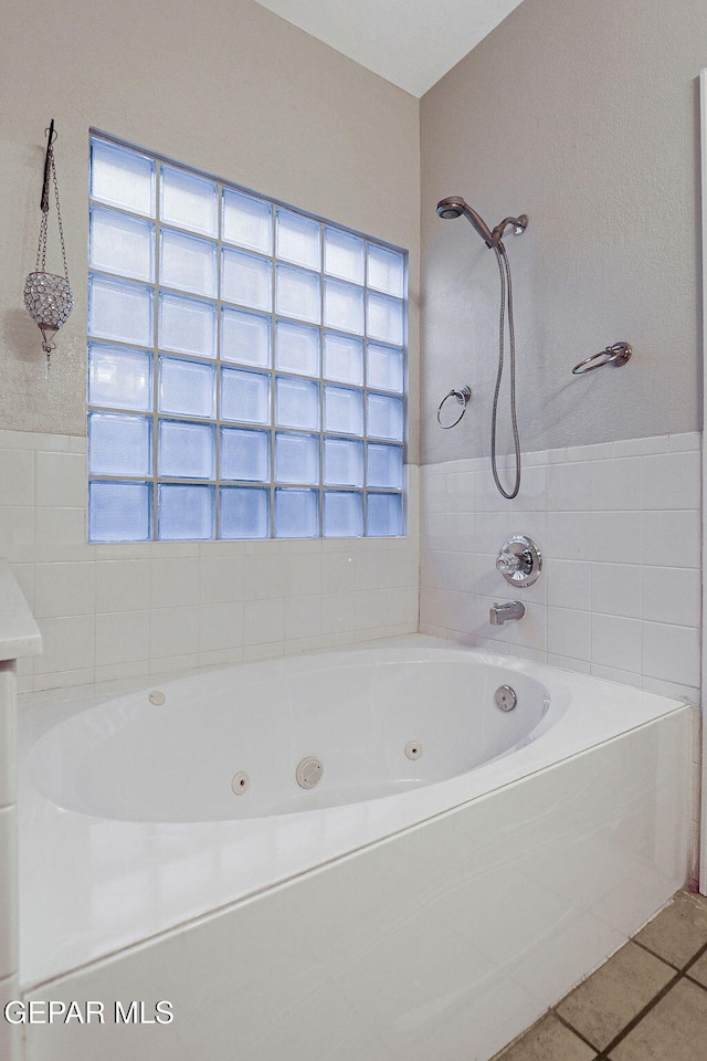 bathroom featuring a wealth of natural light, tile patterned floors, and plus walk in shower