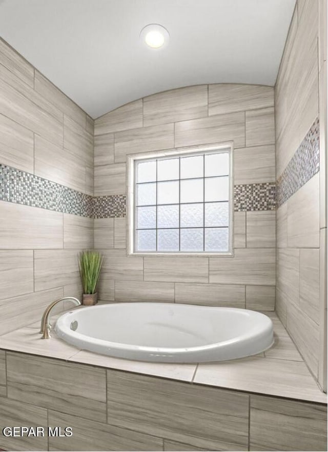 bathroom featuring a relaxing tiled tub