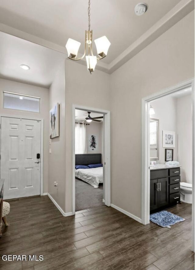 entrance foyer with ceiling fan with notable chandelier