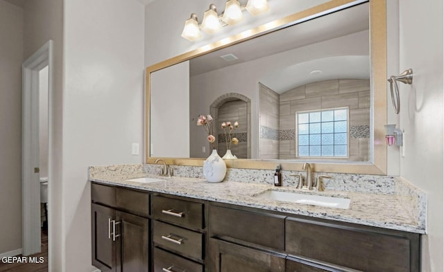 bathroom featuring a shower, vanity, and toilet