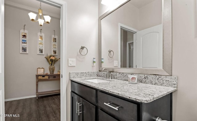 bathroom featuring vanity, hardwood / wood-style flooring, and an inviting chandelier