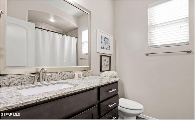 bathroom featuring vanity, toilet, and plenty of natural light