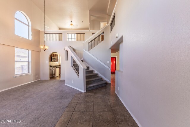 staircase featuring carpet flooring and a towering ceiling