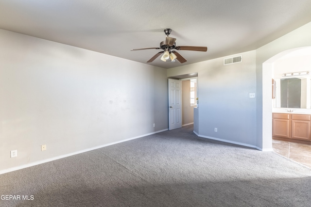 unfurnished room featuring sink, carpet flooring, and ceiling fan