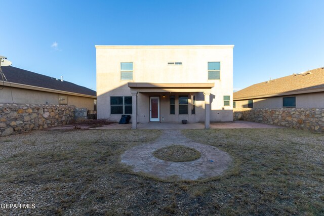 rear view of property featuring a patio area and a lawn