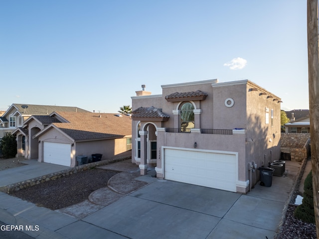 view of front of property featuring central air condition unit and a garage