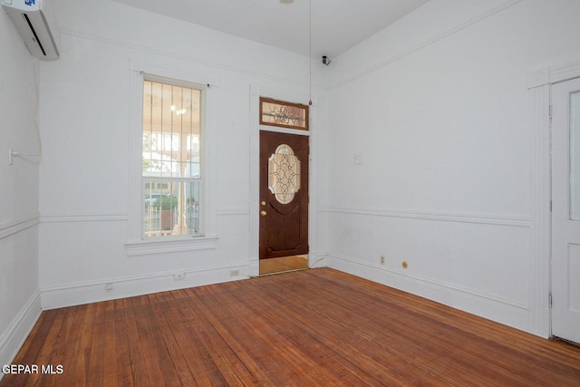 foyer entrance with hardwood / wood-style floors and a wall mounted air conditioner