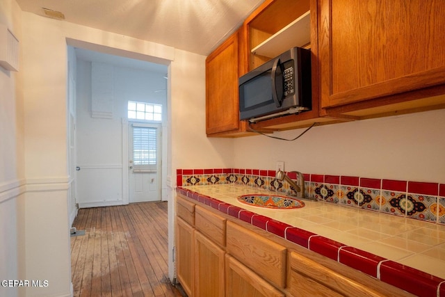 kitchen featuring tile countertops, sink, and hardwood / wood-style flooring