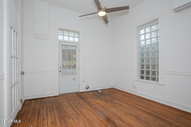 unfurnished room featuring hardwood / wood-style floors, ceiling fan, and a wall unit AC