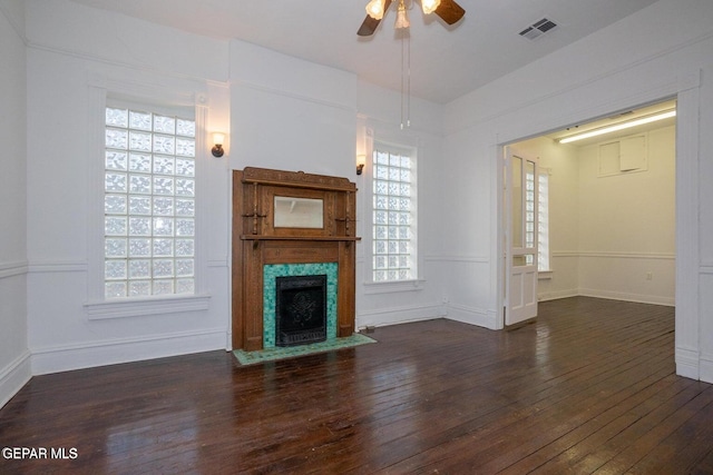 unfurnished living room featuring ceiling fan, dark hardwood / wood-style flooring, and a wealth of natural light