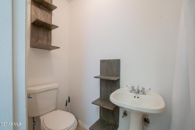 bathroom with curtained shower and toilet