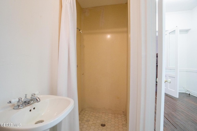 bathroom with a shower with curtain, sink, and hardwood / wood-style flooring