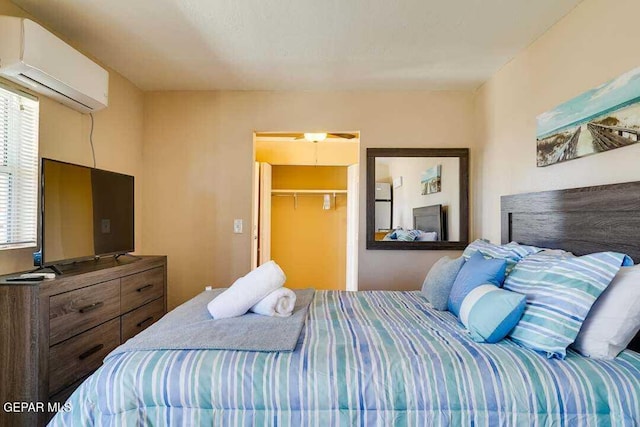 bedroom featuring a wall mounted air conditioner, a spacious closet, and a closet