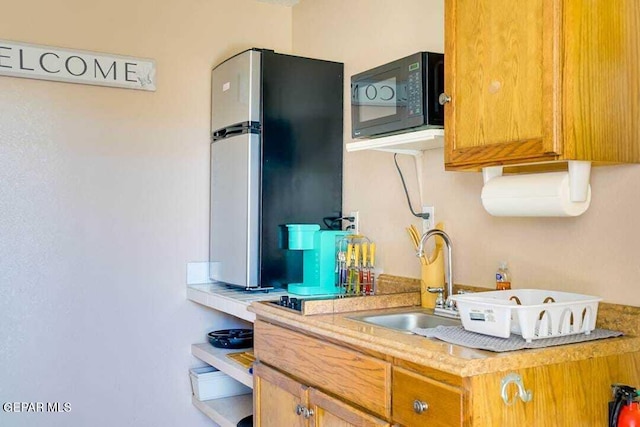 kitchen featuring stainless steel refrigerator and sink