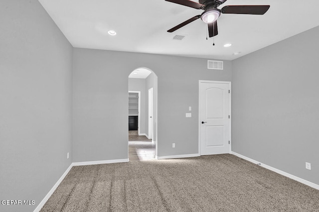 carpeted spare room featuring ceiling fan