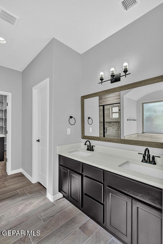 bathroom featuring vanity, hardwood / wood-style floors, and a shower