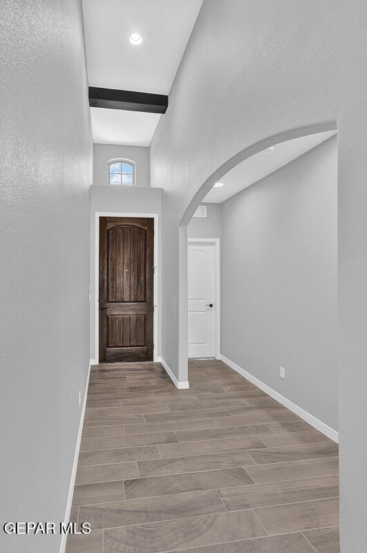 foyer with light hardwood / wood-style flooring and beam ceiling