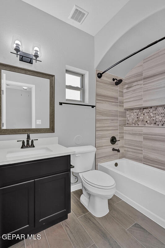 full bathroom with vanity, toilet, and tiled shower / bath