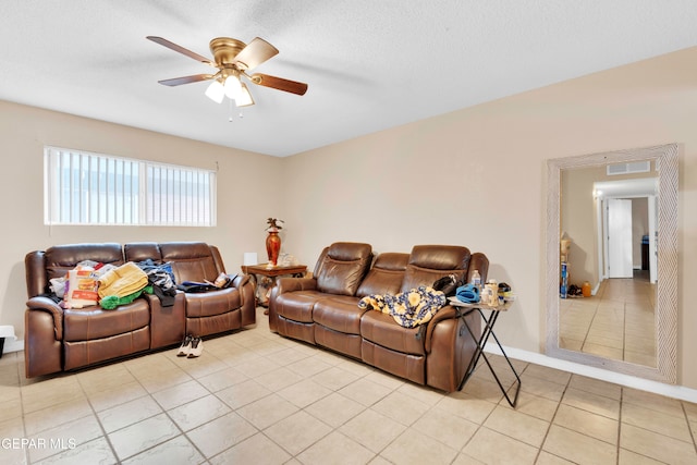 living room with light tile patterned floors, a textured ceiling, and ceiling fan