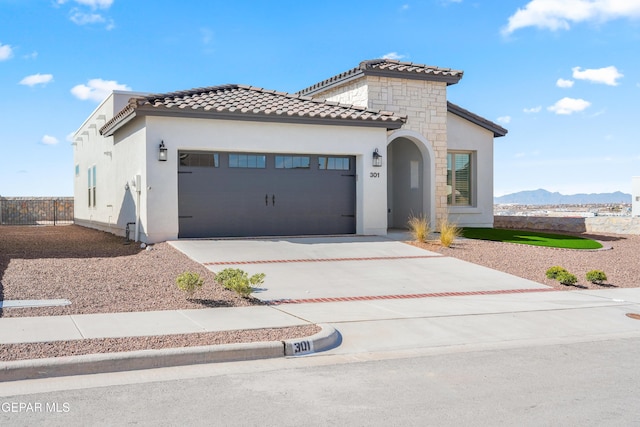 13653 Prime Vista Ct, El Paso, TX 79928 - mediterranean / spanish-style home with an attached garage, driveway, a tile roof, stucco siding, and a mountain view