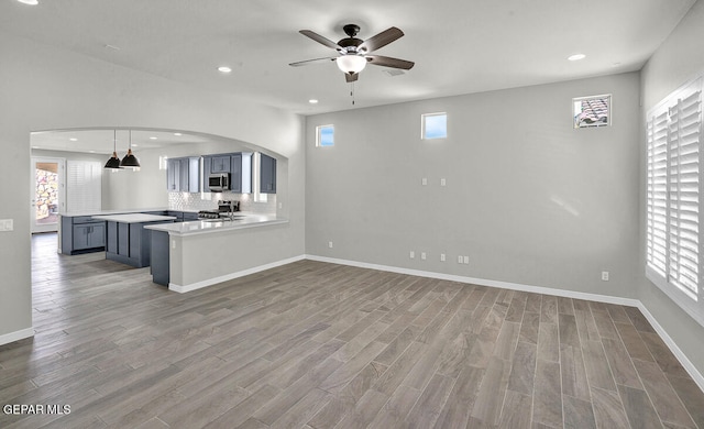unfurnished living room with wood-type flooring and ceiling fan