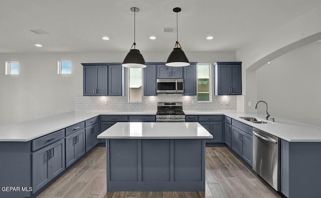 kitchen with plenty of natural light, appliances with stainless steel finishes, sink, and kitchen peninsula