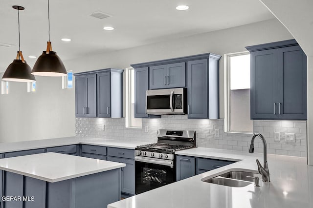 kitchen featuring backsplash, stainless steel appliances, sink, and hanging light fixtures
