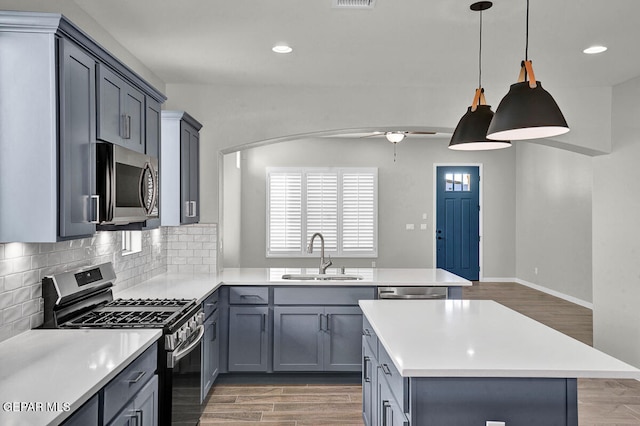 kitchen featuring decorative backsplash, dark hardwood / wood-style floors, sink, decorative light fixtures, and appliances with stainless steel finishes