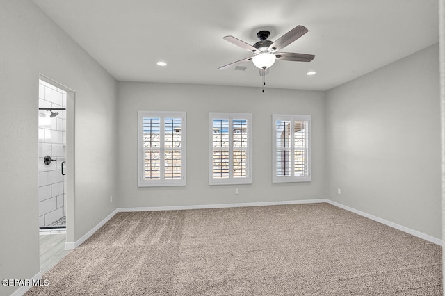 carpeted spare room featuring a healthy amount of sunlight and ceiling fan