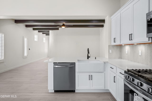 13866 Paseo Central Ave, El Paso, TX 79928 - kitchen with appliances with stainless steel finishes, a sink, light wood-style floors, backsplash, and beamed ceiling