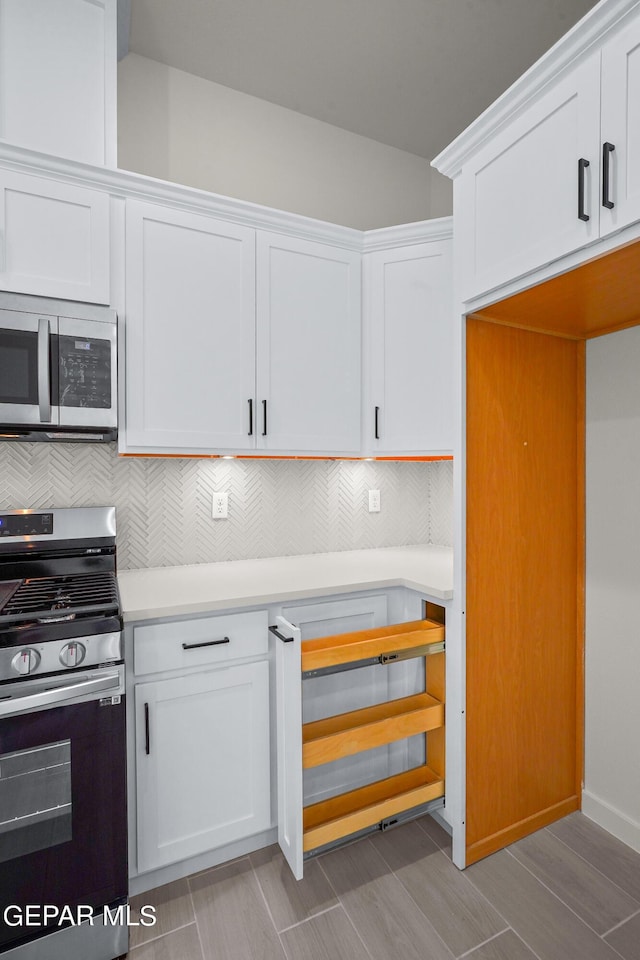 13866 Paseo Central Ave, El Paso, TX 79928 - kitchen featuring stainless steel appliances, tasteful backsplash, light countertops, and white cabinetry