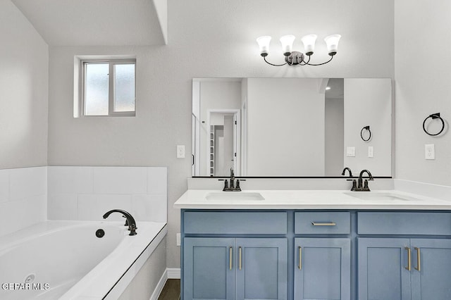 bathroom featuring vanity, an inviting chandelier, and a tub