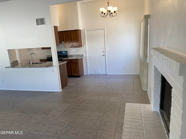 kitchen featuring sink, light tile patterned flooring, black electric range oven, kitchen peninsula, and high vaulted ceiling