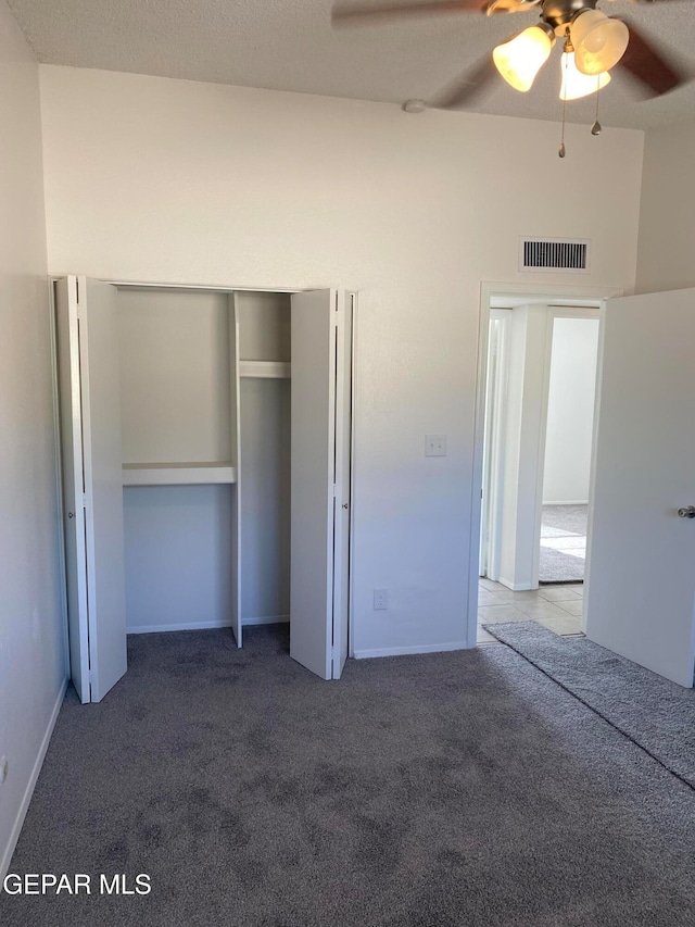 unfurnished bedroom with a closet, ceiling fan, and carpet floors