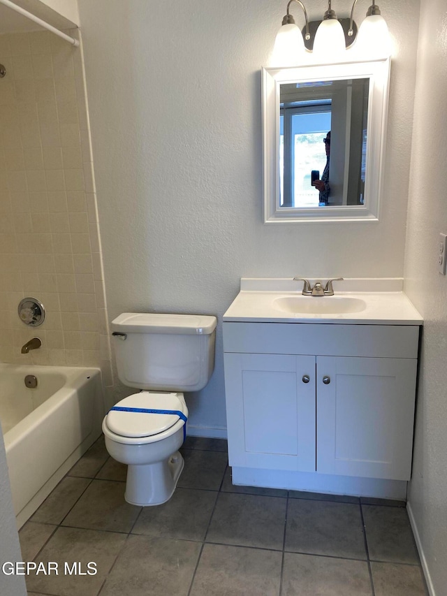 full bathroom featuring vanity, tiled shower / bath combo, toilet, and tile patterned floors