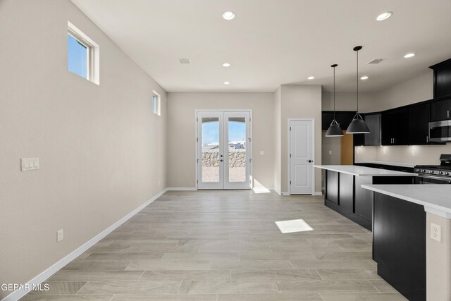 kitchen featuring french doors, appliances with stainless steel finishes, light hardwood / wood-style flooring, and pendant lighting