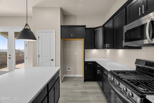 kitchen featuring light hardwood / wood-style floors, stainless steel appliances, and decorative light fixtures