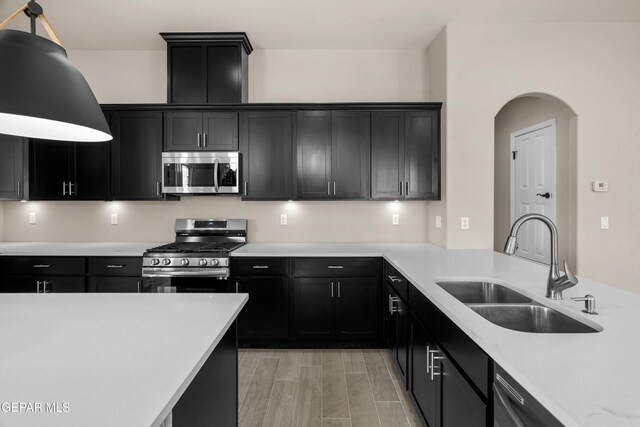 kitchen featuring stainless steel appliances, sink, and light wood-type flooring