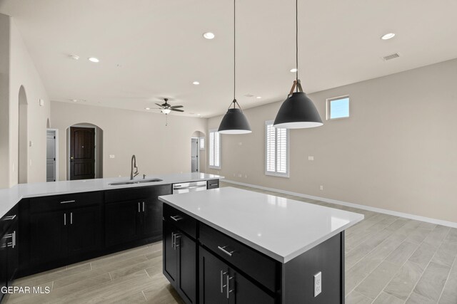 kitchen featuring a kitchen island with sink, light hardwood / wood-style flooring, sink, pendant lighting, and ceiling fan