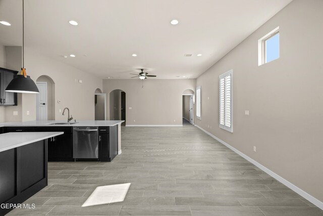 kitchen featuring sink, ceiling fan, pendant lighting, stainless steel dishwasher, and light hardwood / wood-style flooring