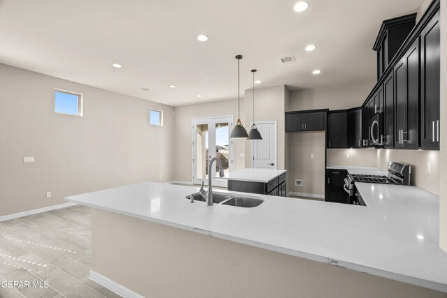 kitchen with appliances with stainless steel finishes, sink, hanging light fixtures, and a wealth of natural light