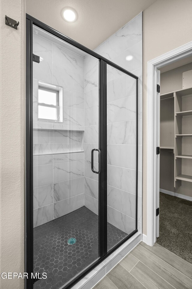 bathroom featuring a shower with shower door