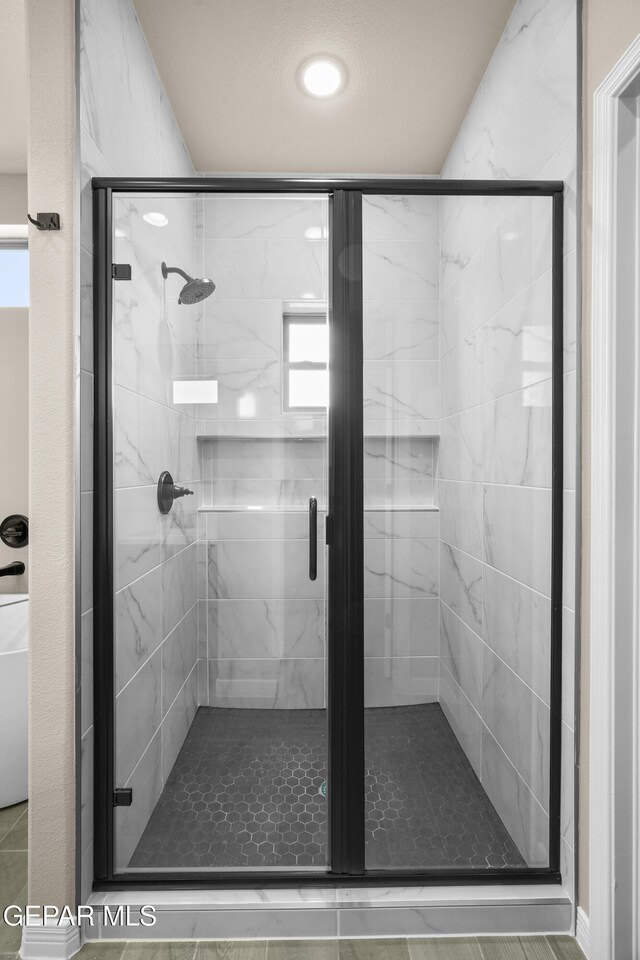 bathroom featuring a shower with door