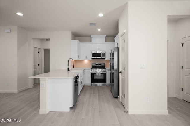 13870 Paseo Central Ave, Horizon City, TX 79928 - kitchen featuring stainless steel appliances, a sink, a peninsula, light countertops, and light wood-style floors