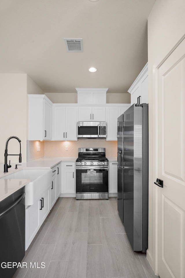 13870 Paseo Central Ave, Horizon City, TX 79928 - kitchen with appliances with stainless steel finishes, a sink, light countertops, white cabinets, and recessed lighting