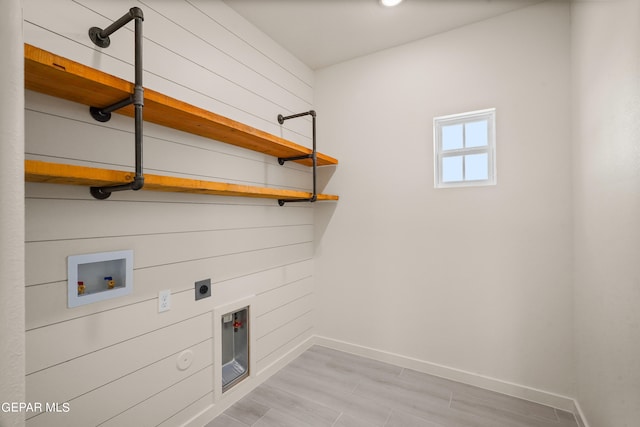 washroom with hookup for an electric dryer, light hardwood / wood-style flooring, and hookup for a washing machine