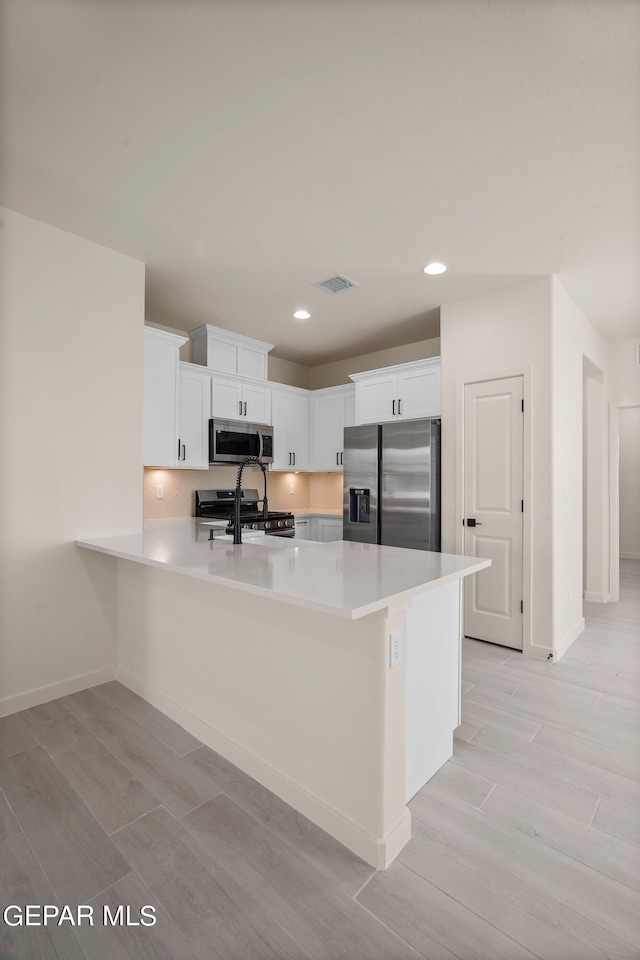 13870 Paseo Central Ave, Horizon City, TX 79928 - kitchen featuring stainless steel appliances, a sink, a peninsula, light wood-type flooring, and recessed lighting